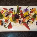 4.	Cut a few thin strips of cucumber skin, and plate all, finishing with crumbling over the cubed feta (with keeping a few cubed pieces whole in the dish). Place the flowers around. Tip/note: what adds an attraction to this dish is the way in which the colours from the ingredients have been plated.